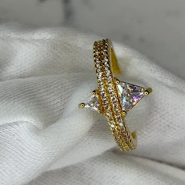 Cute, dainty but a head turner all at the same time!  18k gold plated, clear, brilliant, A+++ CZ round cut stones on the band with a larger and smaller trillion cut stone at the center of the ring, on opposites sides of one another. Made perfectly to be worn individually or in addition to other ring stacks  Expect to get up to 1 year worth of tarnish proof, water resistant wear from our jewelry with proper care. Hypoallergenic.