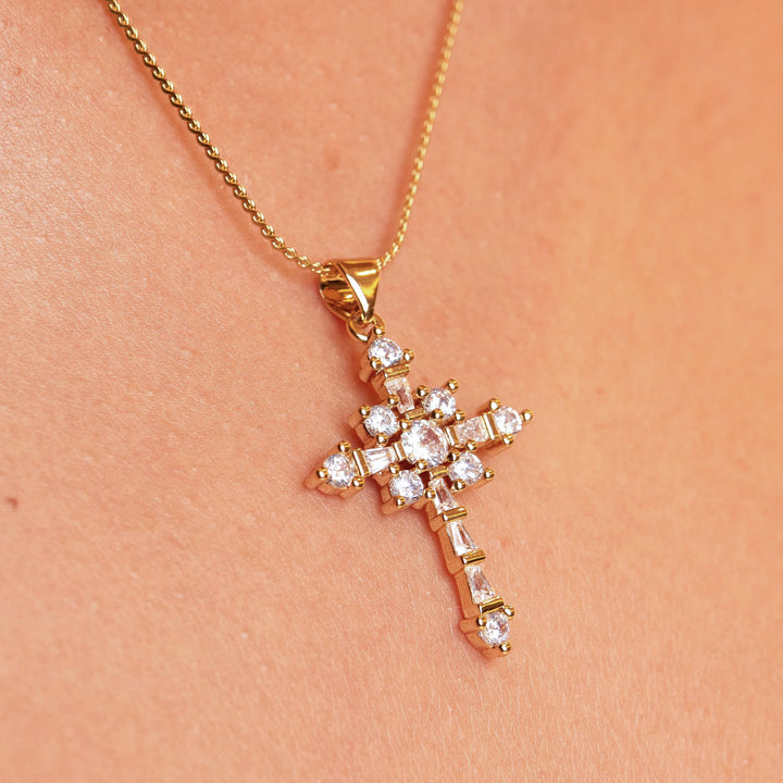 Unique and super luxurious cross pendant necklace made to stand out the crowd! 18k gold plated, round and baguette crystal stone cross pendant necklace. 1" in length 1/2" wide on a 20", serpentine chain necklace. Pendant can be removed from chain and placed on any other chain. Expect to get up to 1 year worth of tarnish proof, water resistant wear from our jewelry with proper care. Hypoallergenic.